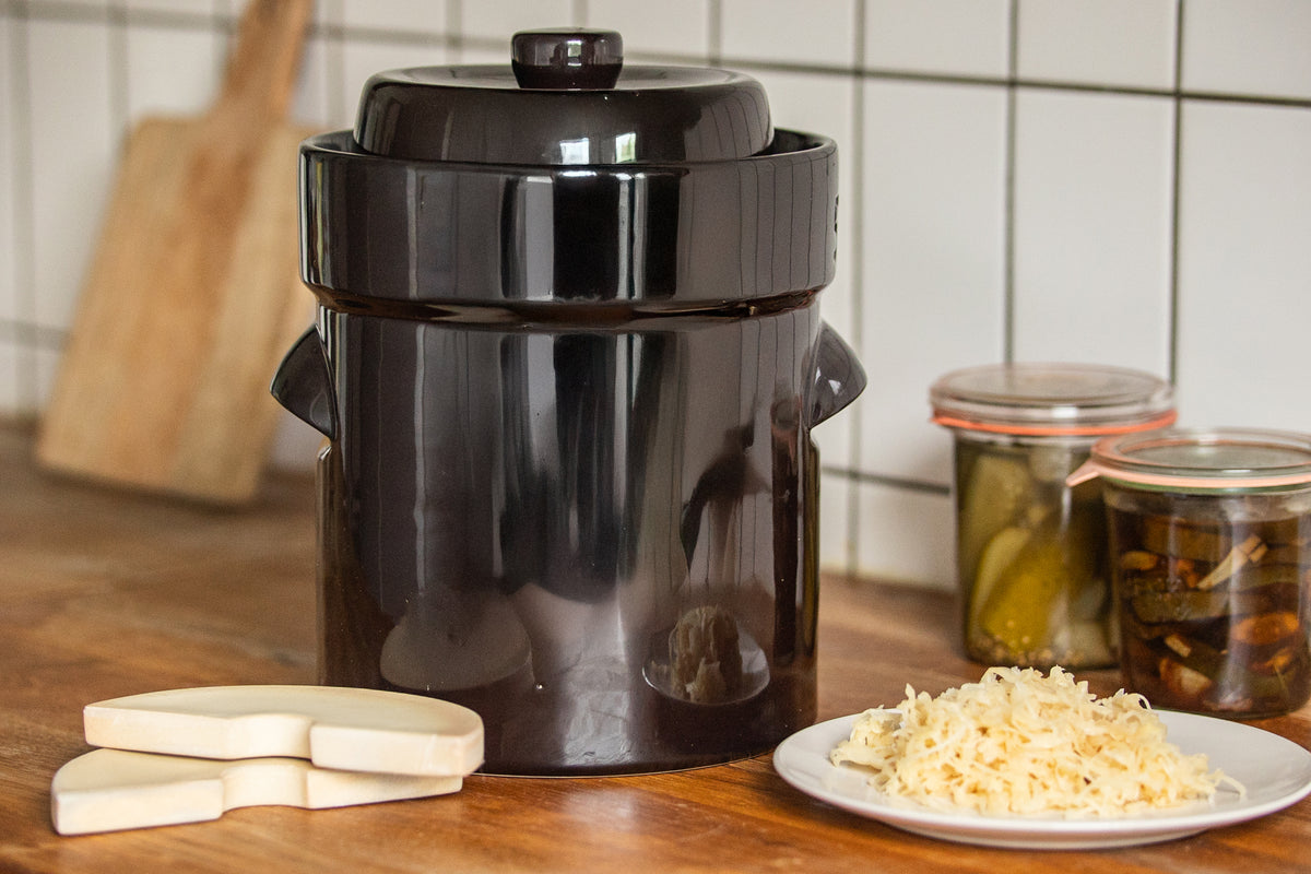 Gärtopf in braun mit Gewichten und Sauerkraut