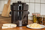 Gärtopf in braun mit Gewichten und Sauerkraut
