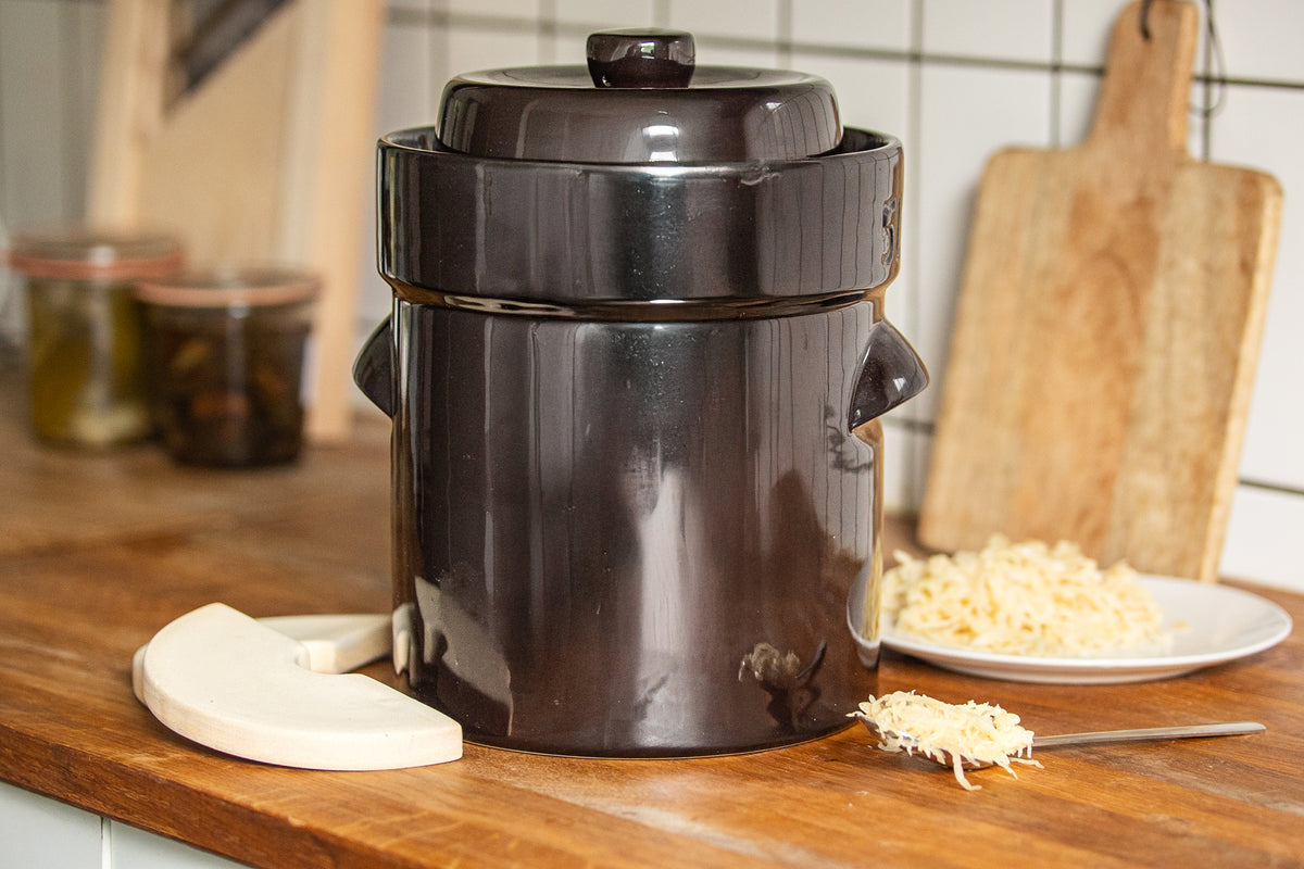 Gärtopf in braun mit Gewichten und Sauerkraut