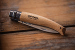 Messer "Opinel" auf Holztisch eingeklappt