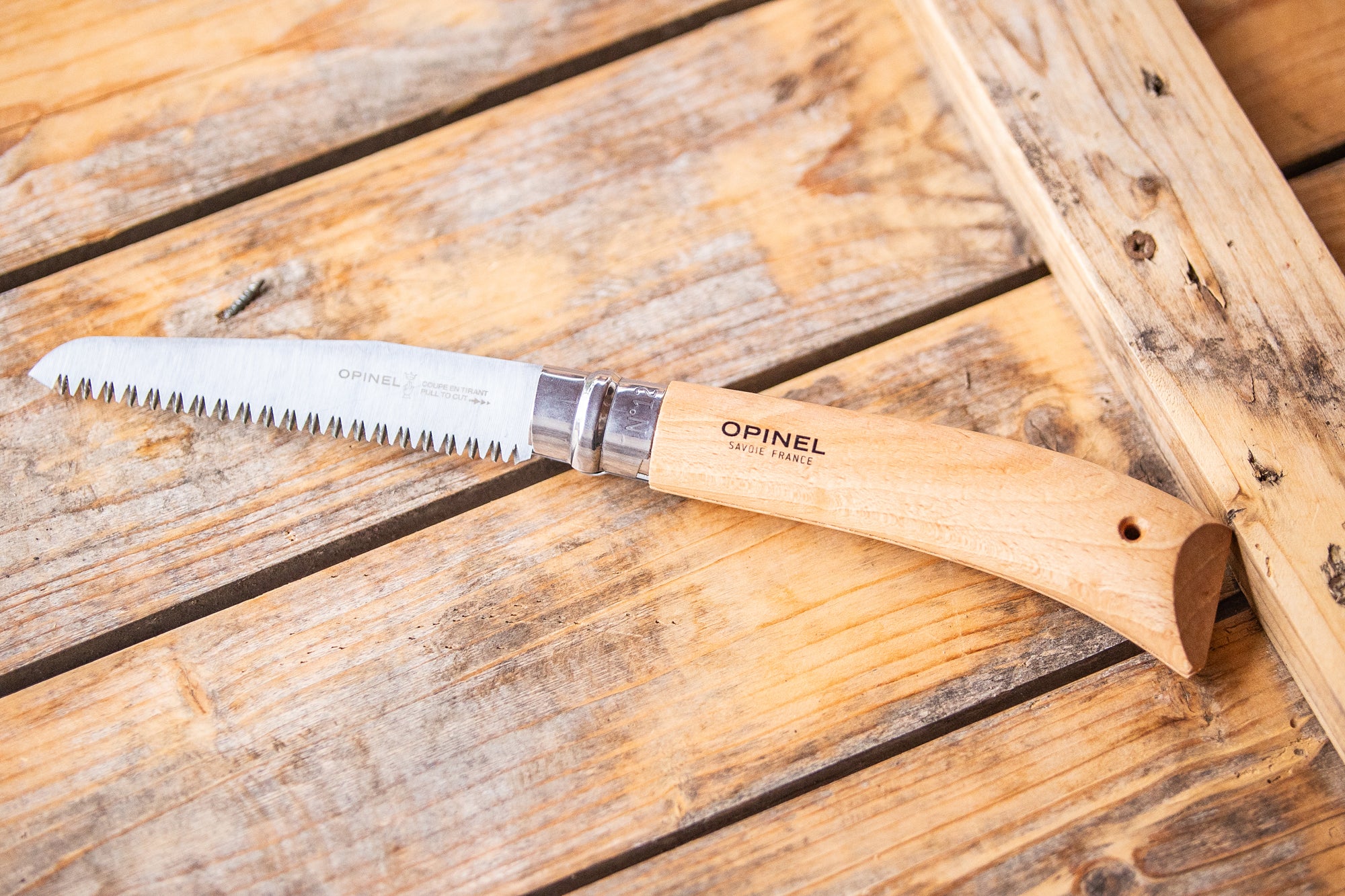 Klappsäge liegt auf einem Holzbrett