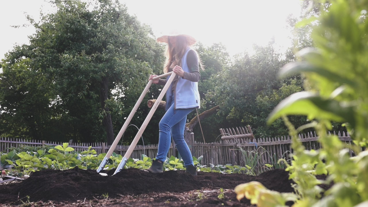 Marie fährt mit Grabegabel durch ein Beet